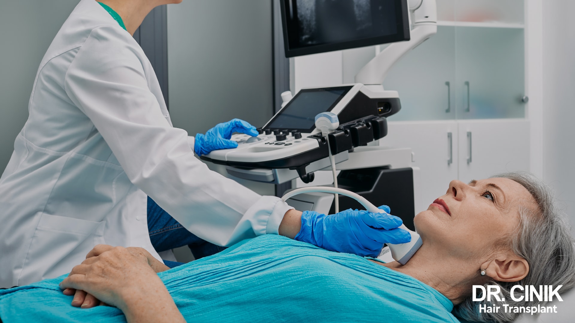 Un'operatrice sanitaria con i guanti passa una sonda ecografica sul collo di una paziente sdraiata per esaminarne la tiroide