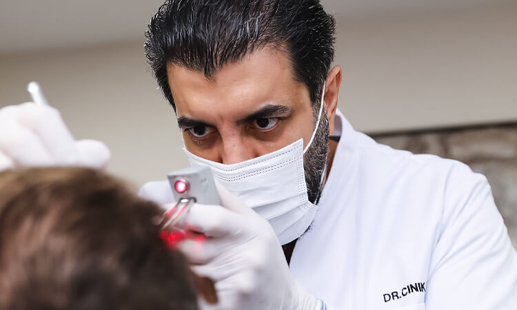 Dr Cinik is checking a patient who had a failed hair transplant to give him a revision plan